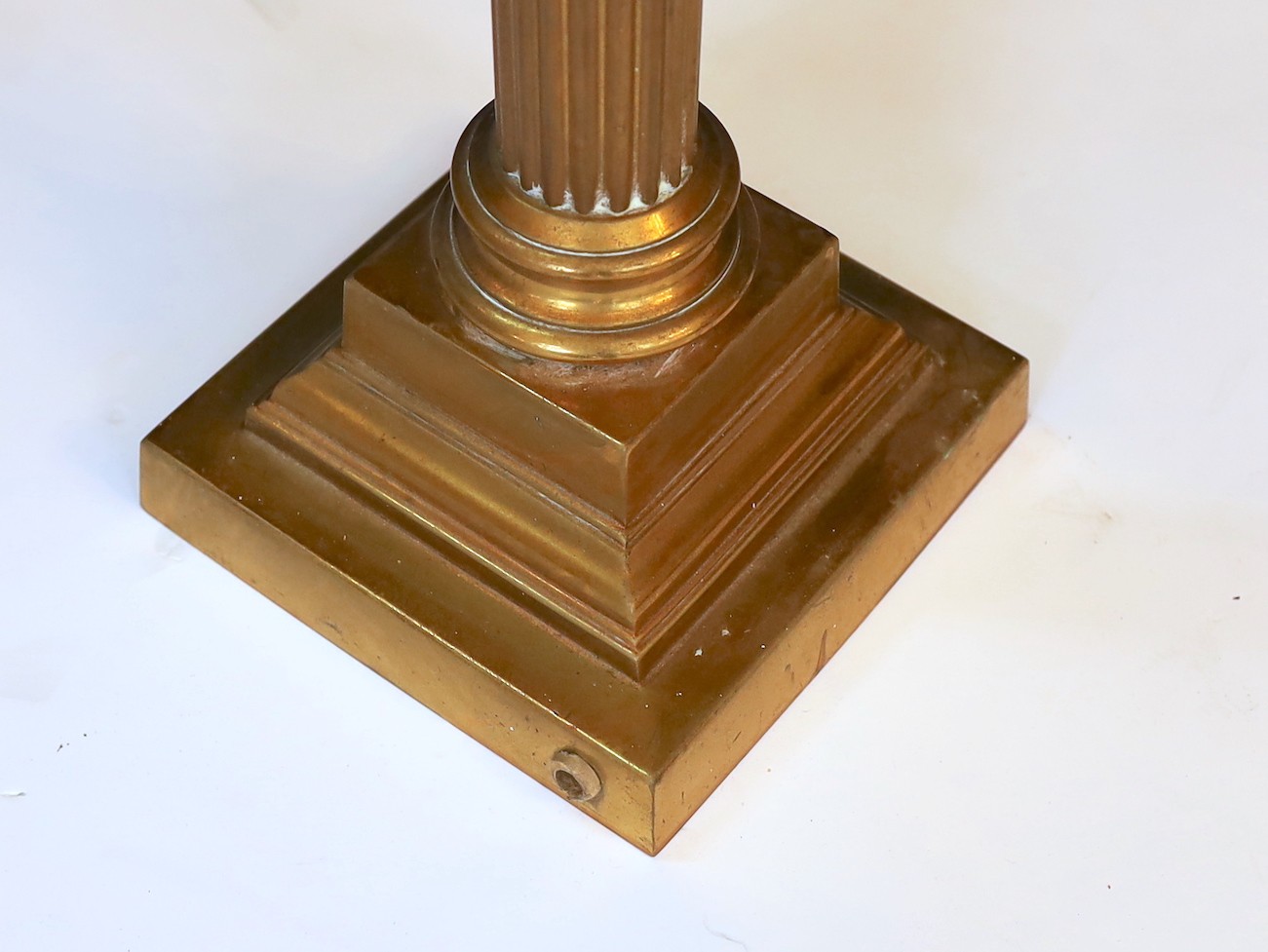 A Victorian lacquered brass fluted column oil lamp with cut ruby glass reservoir, Hinks No2 mechanism, etched cranberry glass shade and flue, height overall 86cm